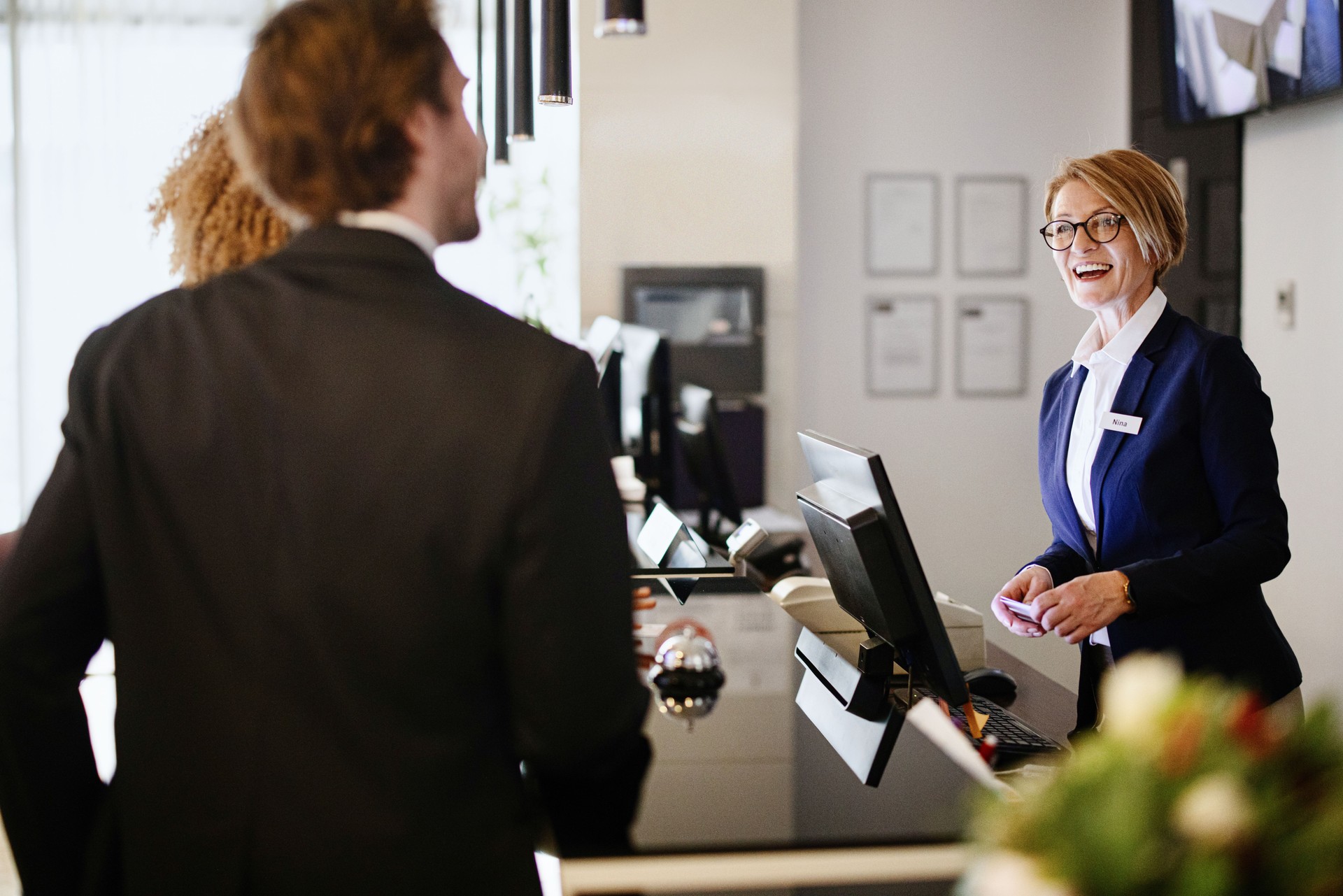 Multi-ethnic business couple arriving at hotel reception desk